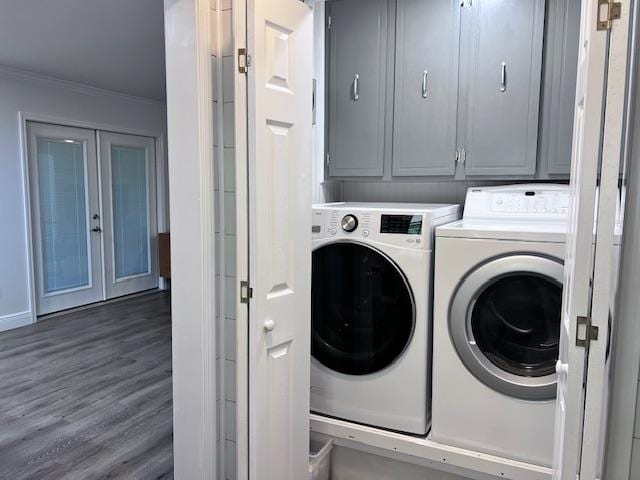 clothes washing area featuring cabinets, washing machine and clothes dryer, crown molding, and dark hardwood / wood-style flooring