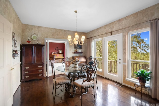 dining space featuring dark wood-type flooring and a chandelier