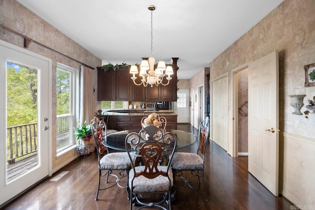 dining room featuring an inviting chandelier and dark wood-type flooring