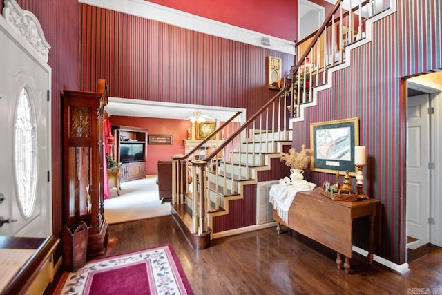 foyer entrance with a towering ceiling and dark hardwood / wood-style flooring