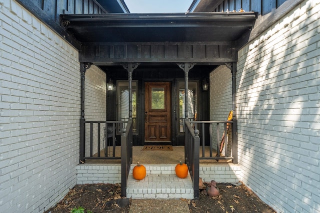 view of exterior entry featuring covered porch