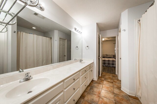 bathroom featuring vanity, a textured ceiling, and tile patterned floors