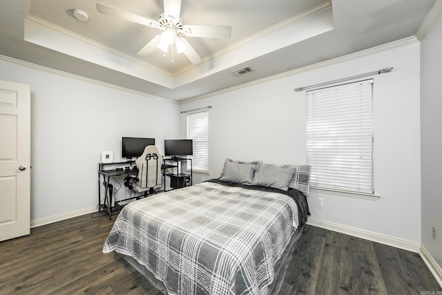 bedroom with ornamental molding, a tray ceiling, dark hardwood / wood-style flooring, and ceiling fan