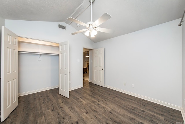 unfurnished bedroom with lofted ceiling, ceiling fan, dark wood-type flooring, and a closet