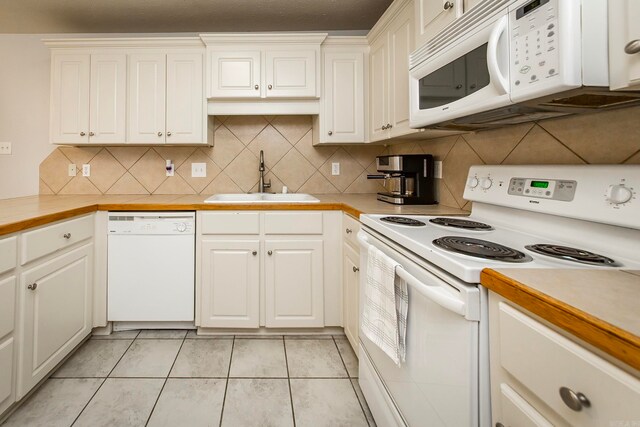 kitchen featuring tasteful backsplash, white appliances, sink, and white cabinetry