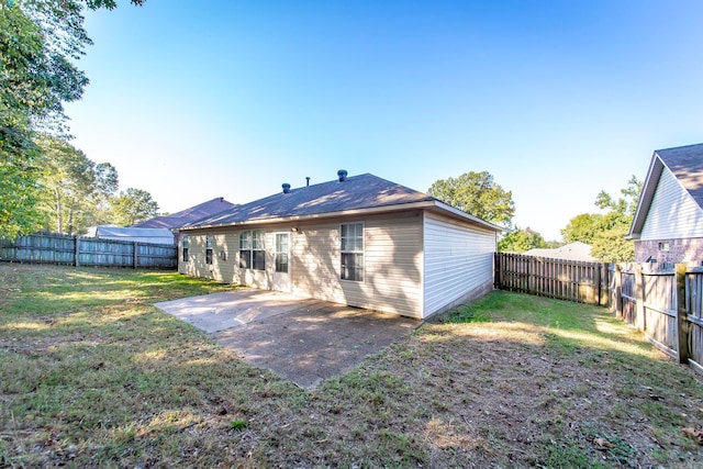 rear view of property with a yard and a patio area