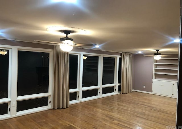 unfurnished living room featuring wood-type flooring and ceiling fan