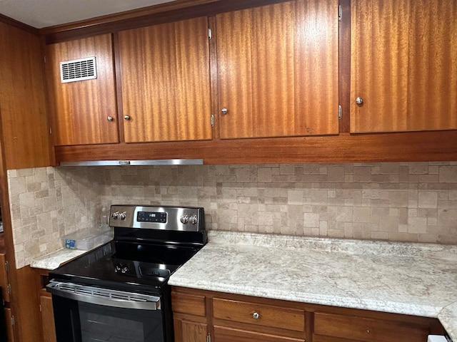 kitchen with tasteful backsplash, light stone countertops, extractor fan, and stainless steel electric range