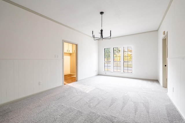 empty room with light colored carpet, crown molding, and a chandelier