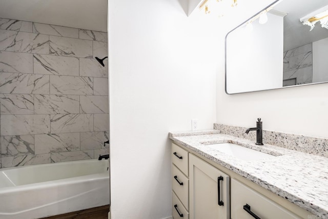 bathroom with tiled shower / bath and vanity