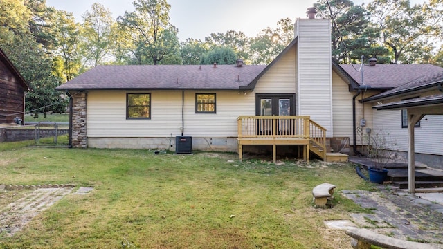 back of house featuring central AC unit, a deck, and a yard