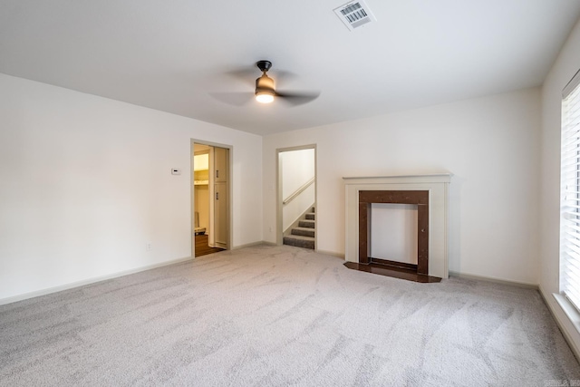 unfurnished living room with ceiling fan, carpet flooring, and a wealth of natural light