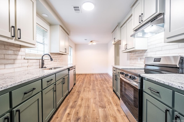 kitchen featuring white cabinets, sink, tasteful backsplash, stainless steel appliances, and light hardwood / wood-style floors