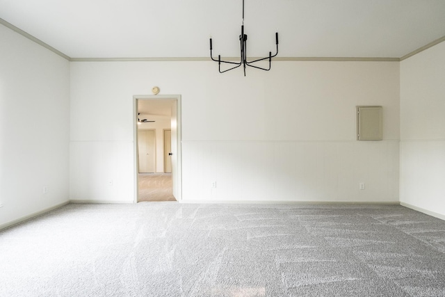 spare room with carpet floors, an inviting chandelier, and ornamental molding