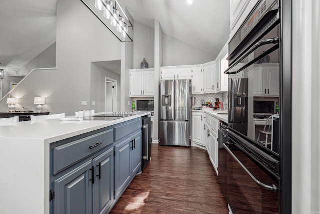 kitchen featuring stainless steel fridge, dark wood-type flooring, high vaulted ceiling, white cabinetry, and black electric stovetop