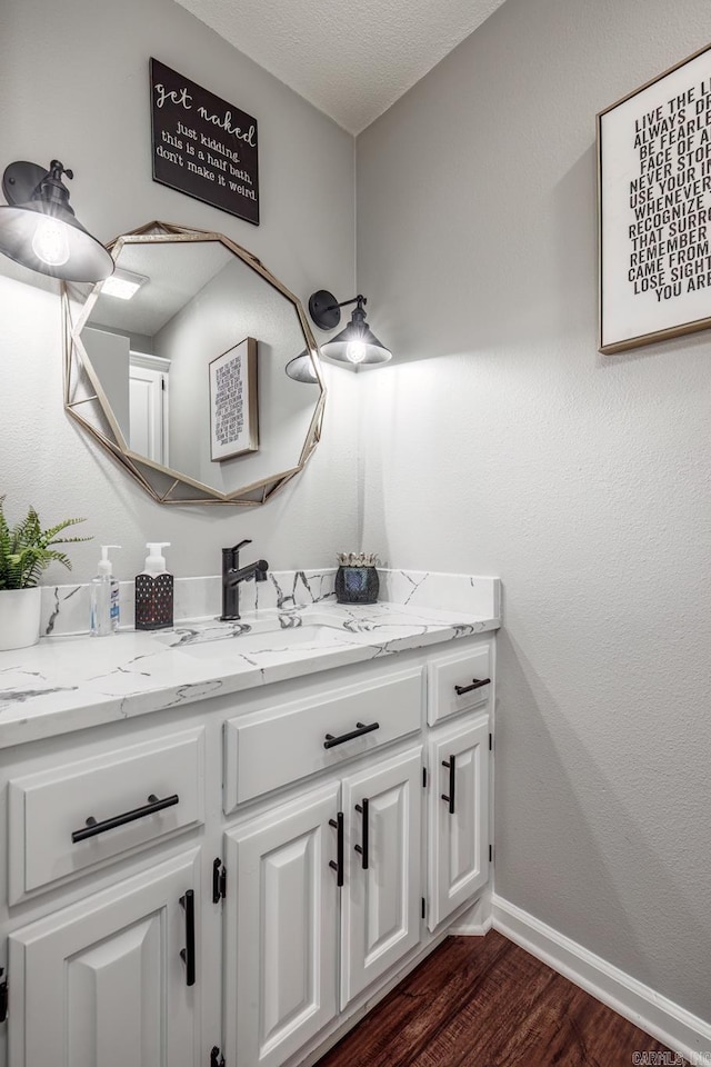 bathroom with vanity, hardwood / wood-style floors, and a textured ceiling