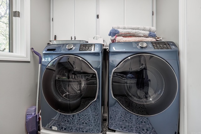 laundry room featuring separate washer and dryer and cabinets