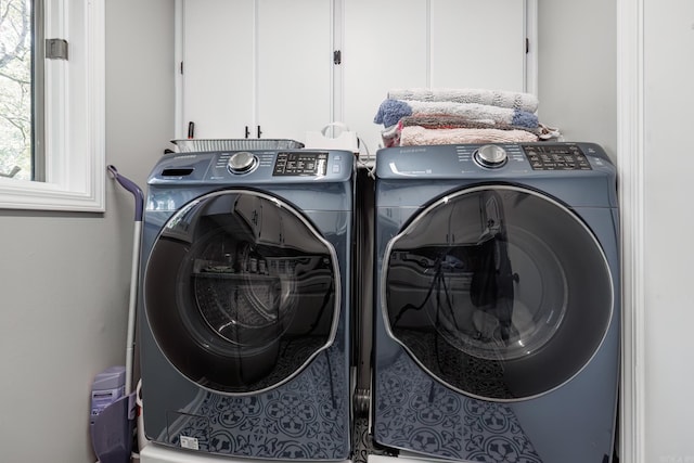 washroom featuring separate washer and dryer and cabinets