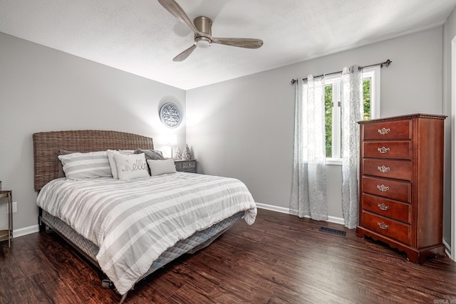 bedroom featuring ceiling fan, a textured ceiling, and dark hardwood / wood-style floors