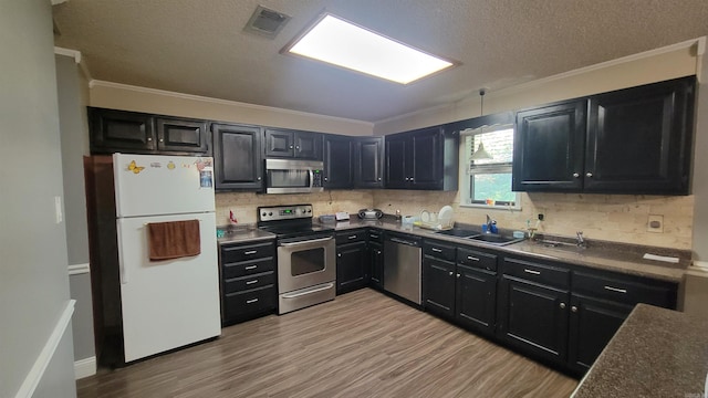 kitchen featuring stainless steel appliances, sink, light hardwood / wood-style floors, crown molding, and a textured ceiling