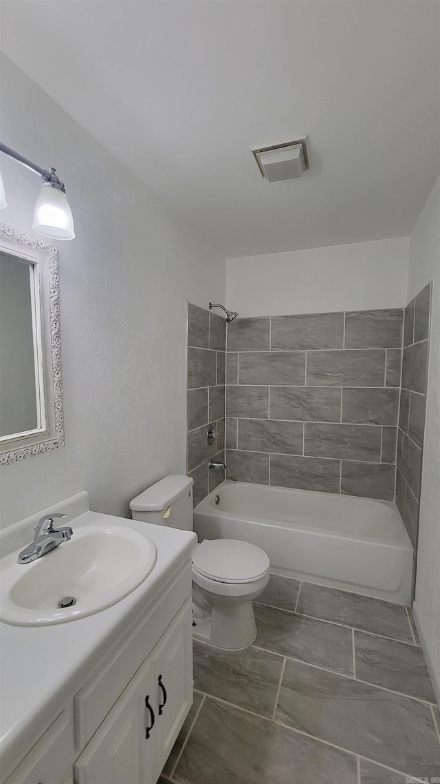 full bathroom with vanity, toilet, and tiled shower / bath combo