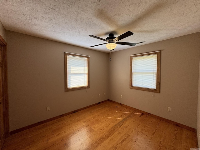 unfurnished room featuring visible vents, ceiling fan, light wood finished floors, and a textured ceiling