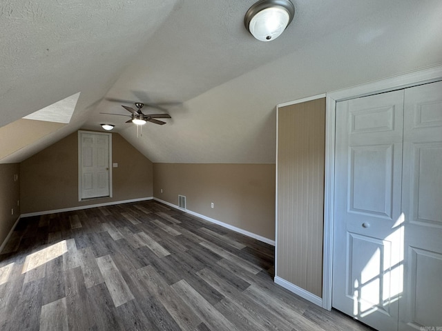 bonus room featuring visible vents, baseboards, vaulted ceiling, and wood finished floors