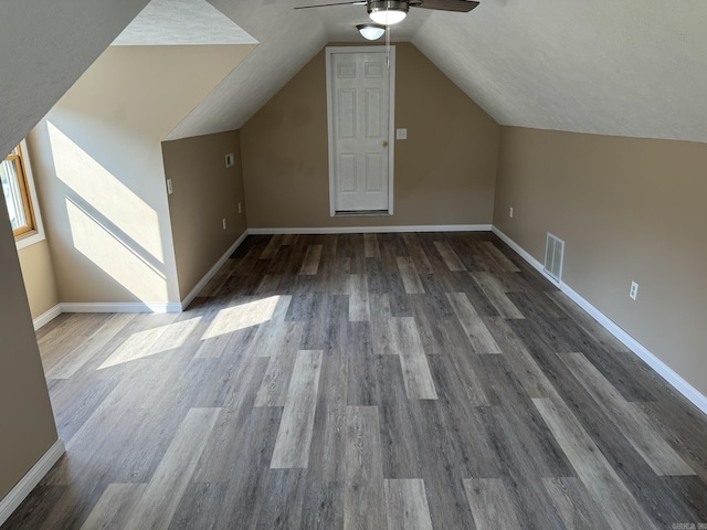 bonus room with baseboards, vaulted ceiling, visible vents, ceiling fan, and wood finished floors