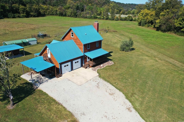 drone / aerial view with a wooded view and a rural view