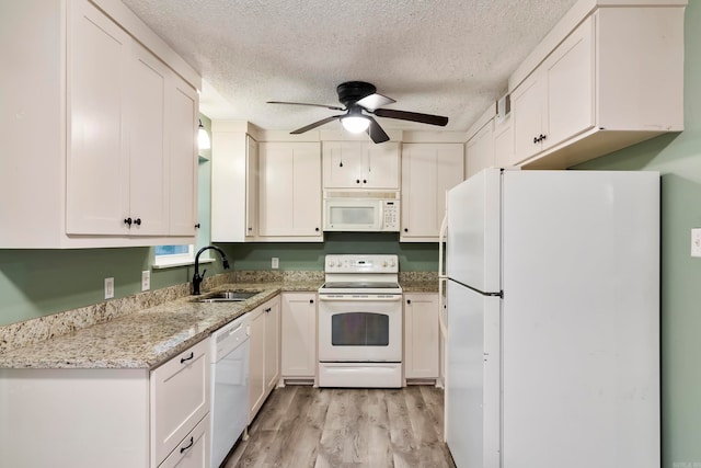 kitchen featuring white cabinets, sink, white appliances, a textured ceiling, and light hardwood / wood-style floors