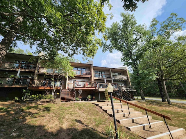 back of house featuring a deck and a lawn