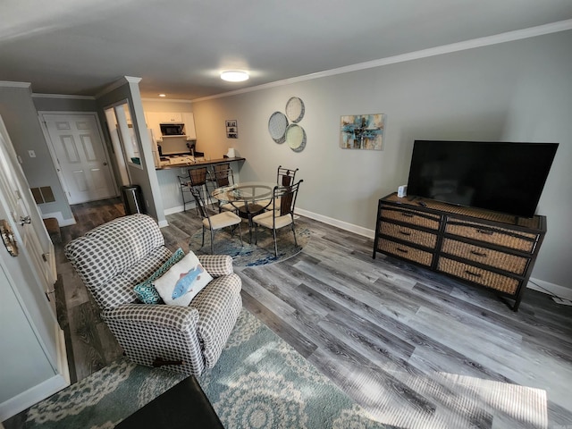 living room featuring wood-type flooring and crown molding