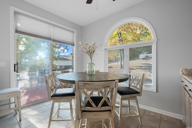 tiled dining area with ceiling fan and plenty of natural light