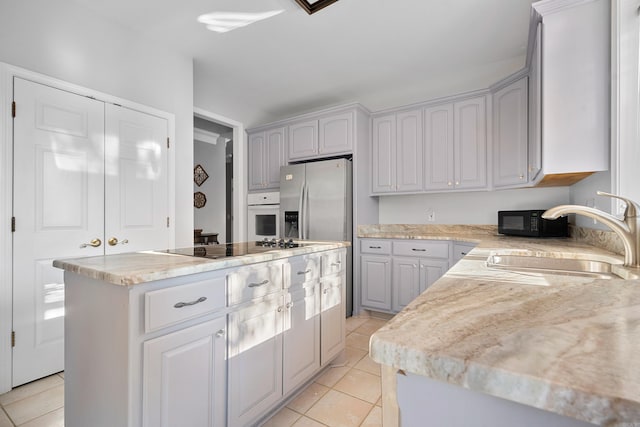 kitchen featuring black appliances, gray cabinets, sink, and a kitchen island