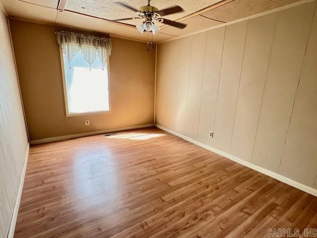 unfurnished room featuring crown molding, hardwood / wood-style floors, and ceiling fan