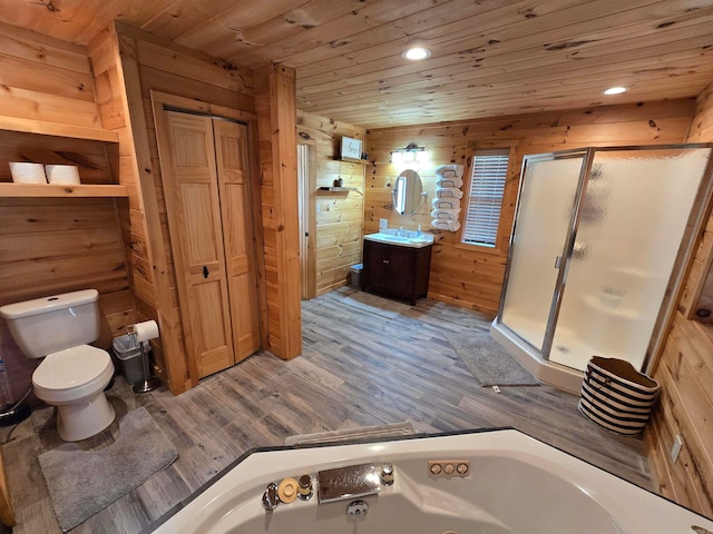 full bathroom with vanity, toilet, wooden walls, shower with separate bathtub, and hardwood / wood-style floors