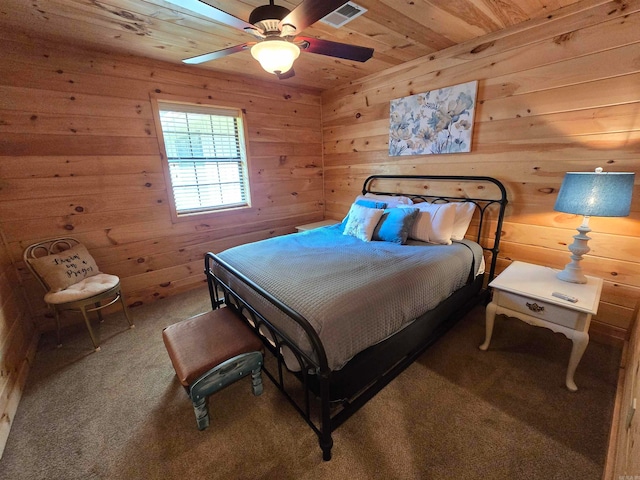 bedroom with ceiling fan, wood walls, wood ceiling, and carpet