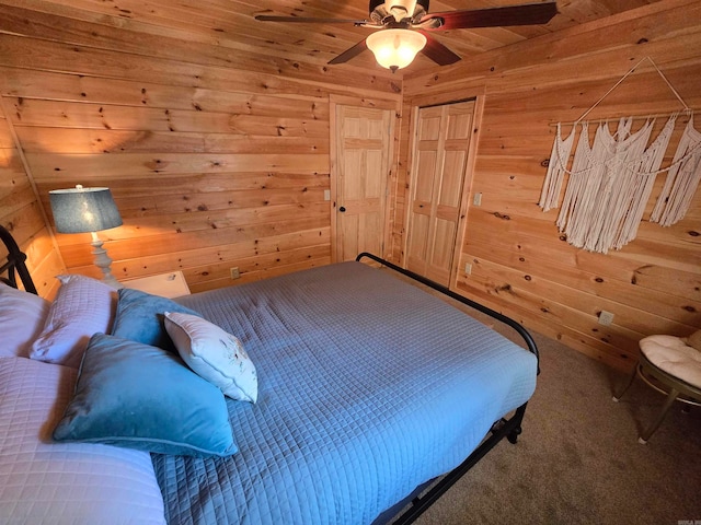 bedroom with ceiling fan, wood walls, and carpet