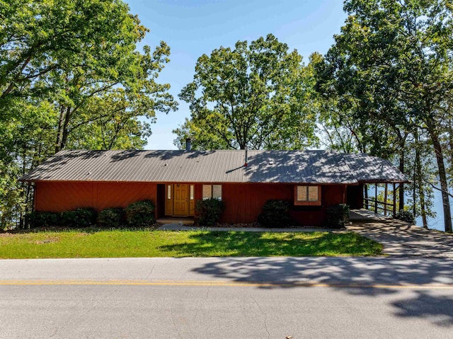 ranch-style home featuring a carport and a front yard