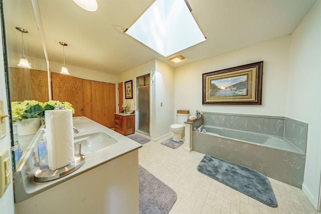 full bathroom with a skylight, separate shower and tub, vanity, and toilet