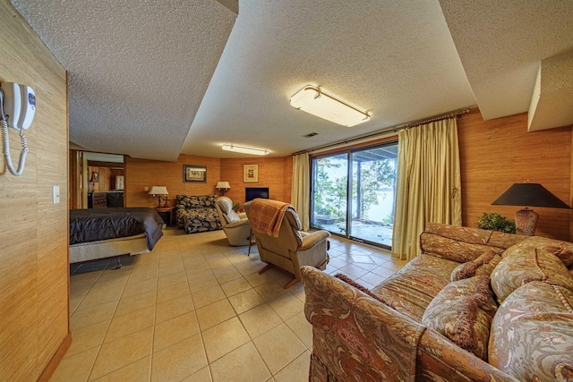 tiled bedroom with a textured ceiling, wooden walls, and access to exterior