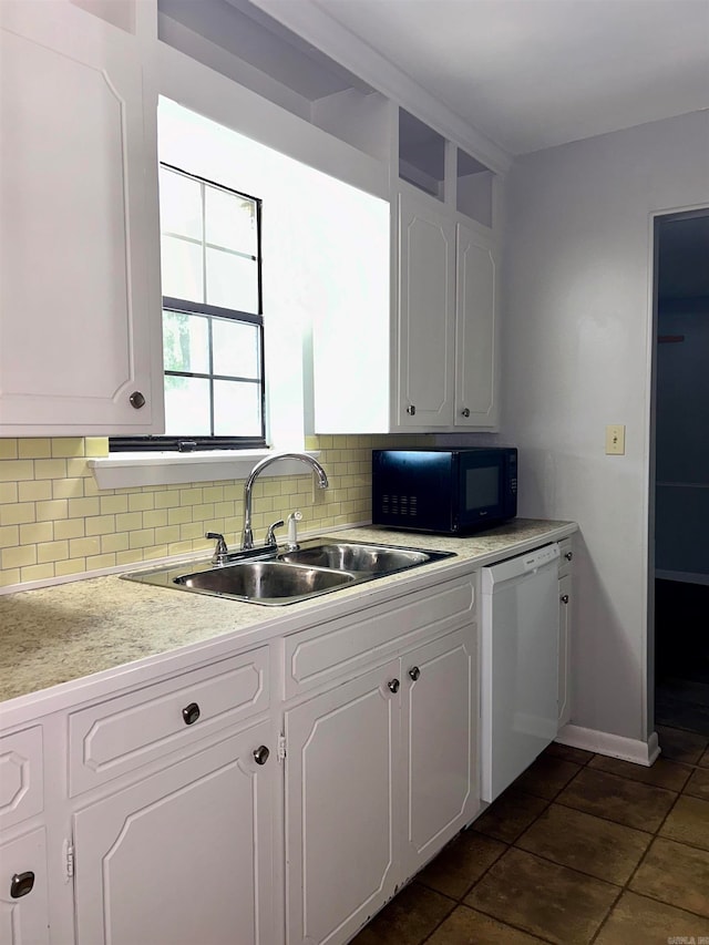 kitchen featuring white dishwasher, decorative backsplash, white cabinetry, and sink