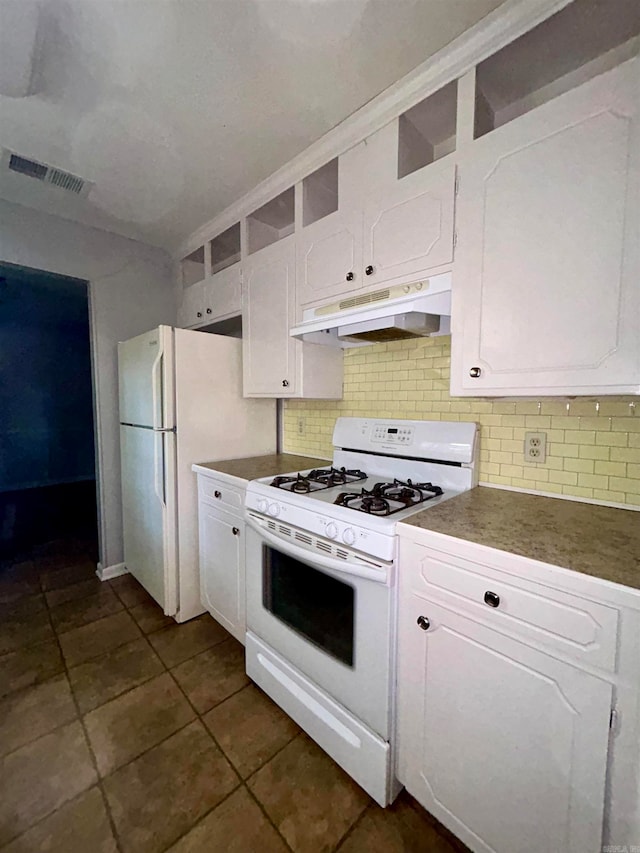 kitchen featuring dark tile patterned floors, white appliances, backsplash, and white cabinets