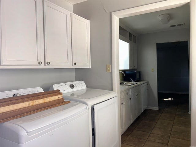 laundry room with separate washer and dryer, dark tile patterned flooring, and sink