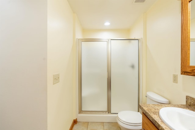 bathroom with toilet, vanity, tile patterned flooring, and walk in shower