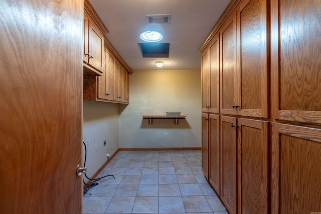 washroom with light tile patterned flooring and cabinets