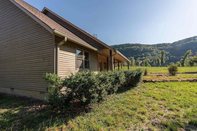 view of property exterior with a mountain view and a yard