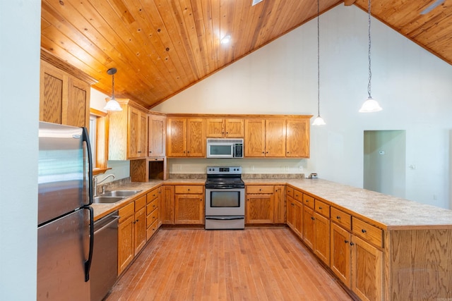 kitchen featuring kitchen peninsula, high vaulted ceiling, hanging light fixtures, and stainless steel appliances