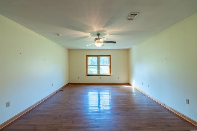 spare room featuring ceiling fan and dark wood-type flooring