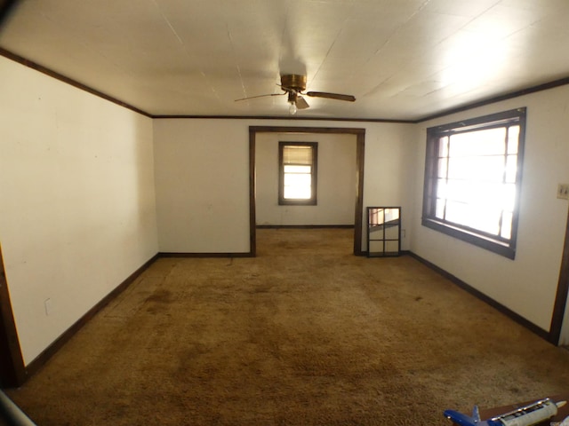 carpeted empty room featuring ceiling fan and baseboards